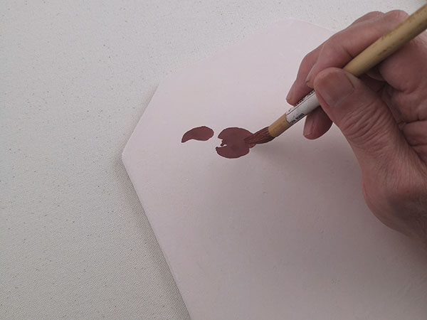 A painter's hand making a precise and clean brush stroke