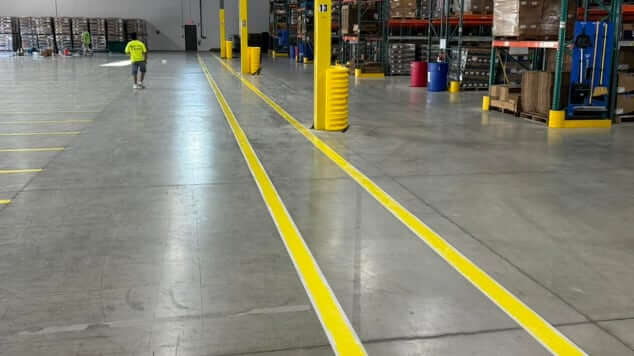 A clean warehouse interior with painted safety lines on the floor